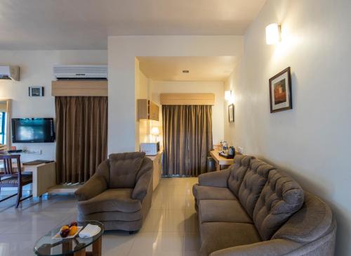 浦那Hotel Phoenix Koregaon Park的客厅配有两张沙发和一张桌子