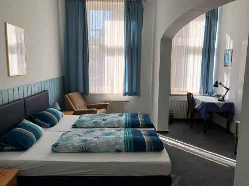 哈廷根Hotel Westfälischer Hof的酒店客房配有两张床和一张书桌