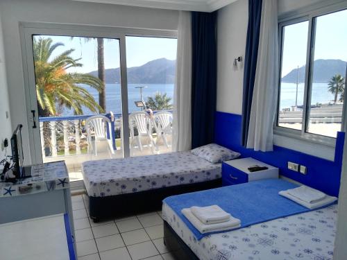 马尔马里斯Uysal Motel Beach的一间带两张床的卧室和一个海景阳台