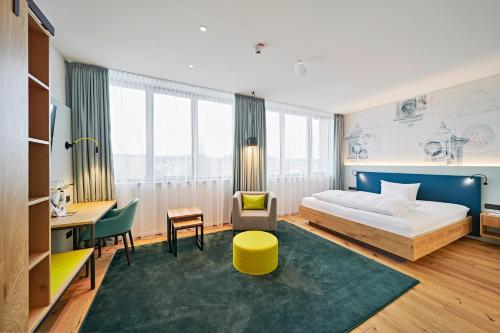 黑林山区圣格奥尔根Hotel Federwerk的配有一张床和一张书桌的酒店客房