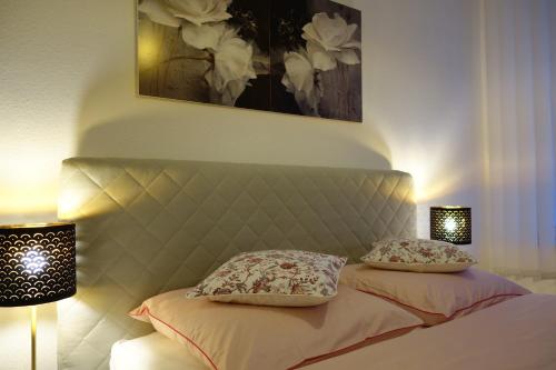 伍珀塔尔Nettes, gemütliches Apartment的一间卧室配有一张带两个枕头和两个灯的床。