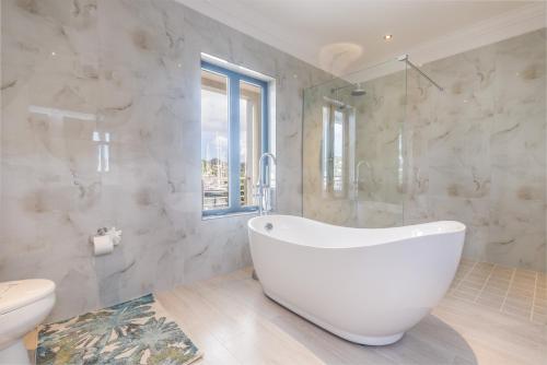 格罗斯岛Waters Edge Villas by Bay Gardens Resorts的白色的浴室设有浴缸和卫生间。
