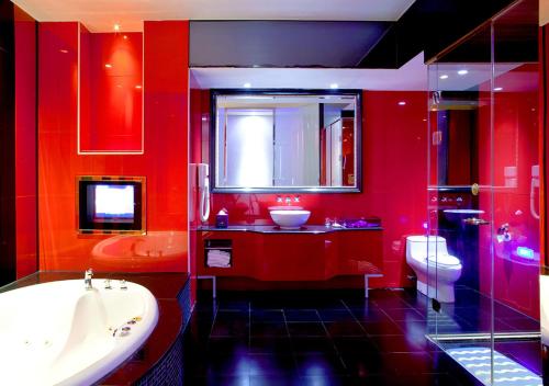 高雄御宿Motel-明诚馆的红色的浴室设有浴缸、水槽和卫生间