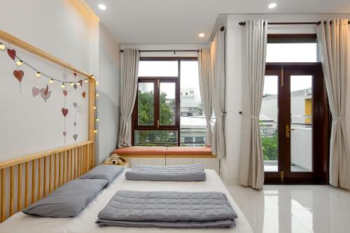 岘港Siro House Da Nang Homestay的带窗户的客房内的两张床