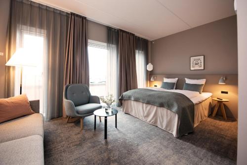 欧登塞Hotel Odeon的酒店客房配有一张床、一把椅子和一张沙发