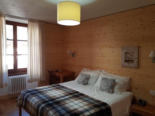 布兰兹佩德雷蒂酒店的一间卧室设有一张床和木墙