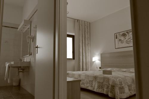 福萨诺罗曼尼西欧酒店的一间卧室配有床、水槽和窗户