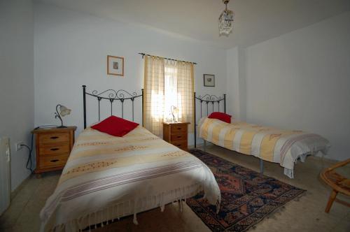托罗克斯Angustias的一间卧室设有两张床、一个窗户和一个地毯。