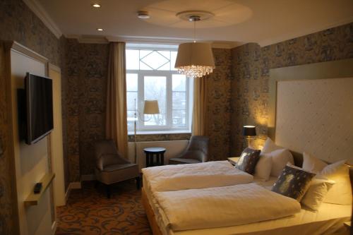 马瑟尔贝格Kurhaus Masserberg的酒店客房设有两张床和吊灯。