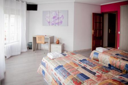 洛格罗尼奥巴赫克德尔埃布罗旅馆的一间卧室配有两张床和一张桌子