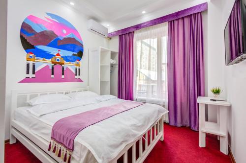 比什凯克WHITE HOTEL & HOSTEL的一间卧室配有一张大床和紫色窗帘