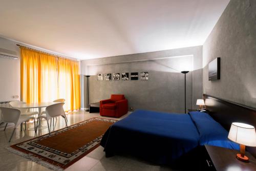 墨西拿安诺齐亚塔住宿酒店的一间卧室配有蓝色的床和桌椅