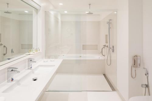 巴西利亚B Hotel Brasilia的白色的浴室设有2个盥洗盆和淋浴。