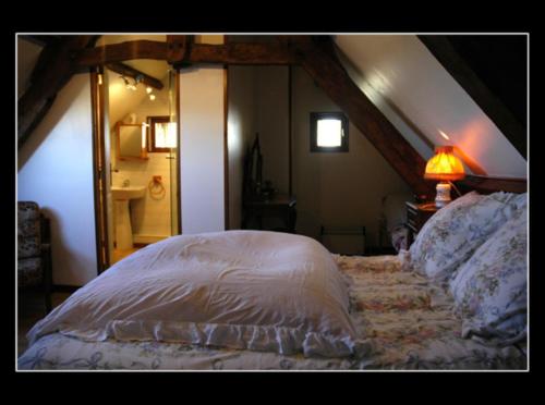 Longues-sur-Mer玛丽斯和让皮埃尔酒店的阁楼卧室配有床