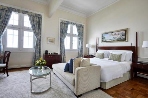 里约热内卢Copacabana Palace, A Belmond Hotel, Rio de Janeiro的卧室配有一张白色的大床和一张沙发。