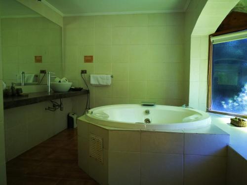 圣何塞德迈波SEL Lodge - Aventura y Descanso的带窗户的浴室设有大浴缸