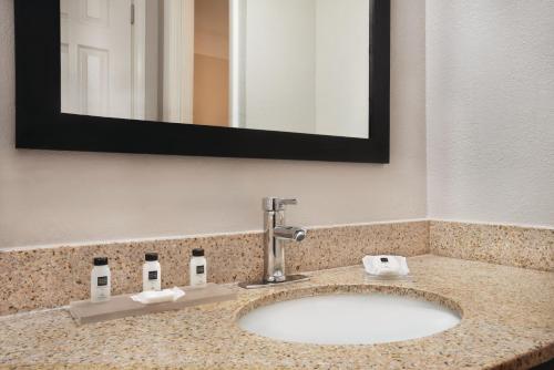 印第安纳波利斯印第安纳州印第安纳波利斯东部丽怡酒店及套房的一间浴室水槽,位于带镜子的酒店客房内