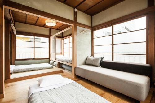 东京Minato-ku - House / Vacation STAY 12127的客房设有两张床、一张沙发和窗户。