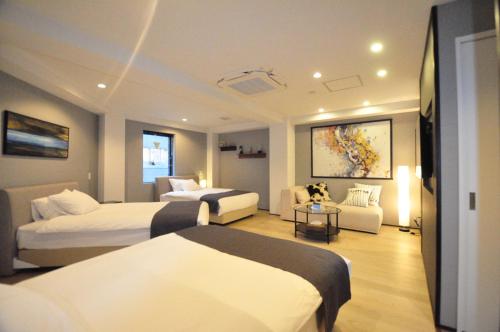 大阪Senlax Inn Osaka的酒店客房,设有两张床和一张沙发