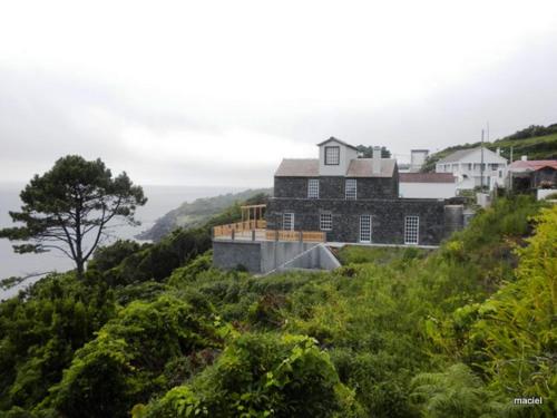 拉日什杜皮库阿瓜达别墅的一座山丘上的房屋,背景是大海