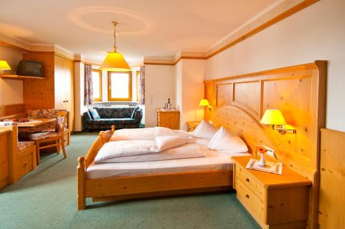 布鲁尼科Hotel Tannenhof的一间卧室配有一张大木床。