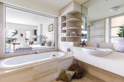 悉尼沃森海湾精品酒店的带浴缸、水槽和镜子的浴室