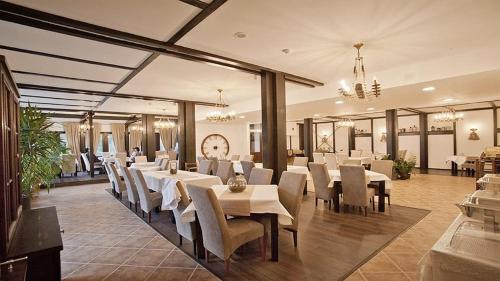 锡纳亚Hotel Regina的用餐室配有白色的桌子和白色的椅子