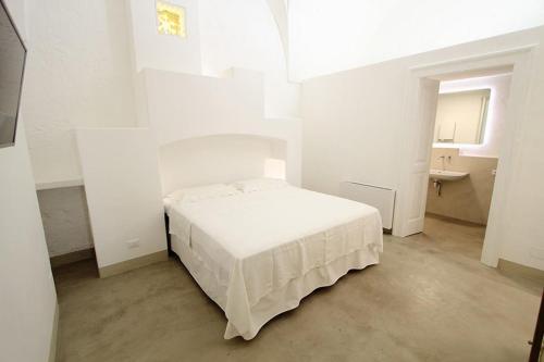 马蒂诺Relais Palazzo Zaccaria的白色卧室设有床铺和水槽