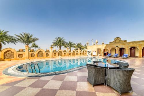 斋沙默尔丘齐达尼宫殿酒店的一个带游泳池和棕榈树的度假村