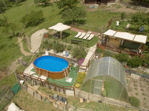 Serra RiccòAgriturismo Terra e Cielo的享有后院的空中景致,设有游泳池和房屋