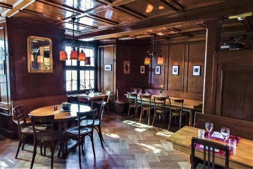 苏黎世利马索夫酒店的餐厅拥有木墙和桌椅