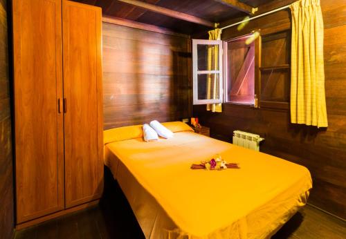 Esponellá艾斯波尼亚露营地的窗户房间里一张黄色的床