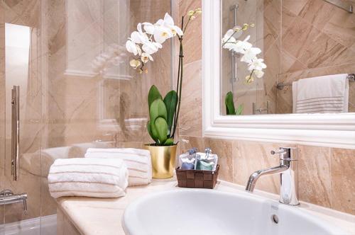 米兰Magville的浴室配有盥洗盆、镜子和浴缸