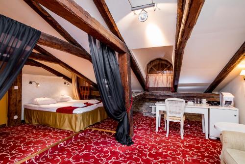 塔林美利通旧城伽登酒店的卧室配有一张床和一张桌子及椅子