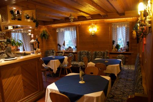 圣维吉利奥赞致亚纳酒店的一间设有两张桌子的用餐室和一间酒吧