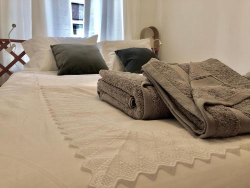 阿姆斯特丹Bee Amsterdam - central apartment in the trendy Jordaan的一张带毯子和枕头的白色床