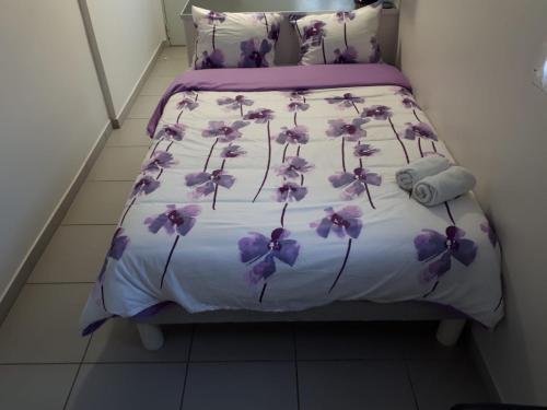 阿维尼翁studio climatisé的一张床上的紫色花朵