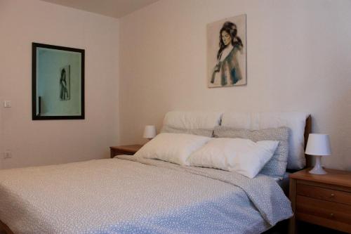 福尔加里亚Trentino Apartments - Casa Corn的卧室配有一张床,墙上挂有两张照片
