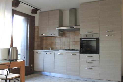 福尔加里亚Trentino Apartments - Casa Corn的厨房配有木制橱柜和炉灶。
