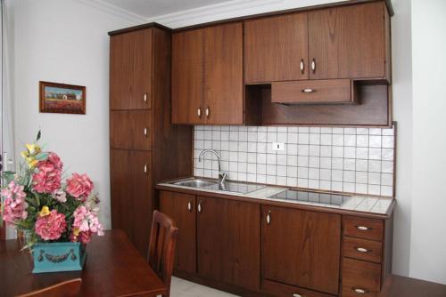 格罗塞托港卡夫普里斯科公寓的厨房配有木制橱柜和鲜花桌