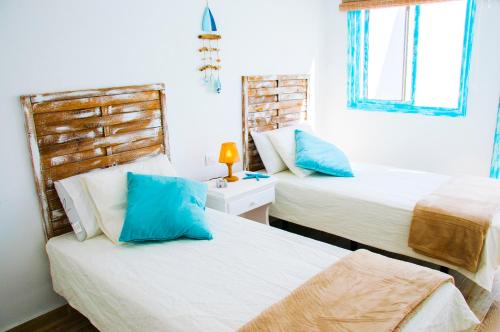 法马拉Casa Ada 2的一间卧室配有两张带蓝色枕头的床