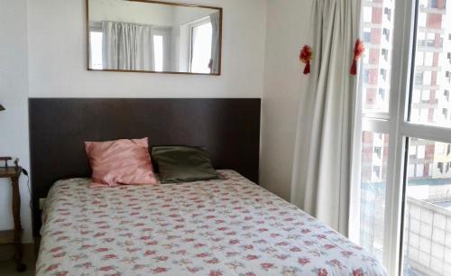 马德普拉塔Mar del Plata的一间卧室配有一张带镜子的床和窗户