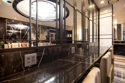 川崎The Grandeur Hotel的一间设有黑柜台和时钟的餐厅