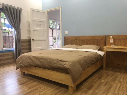 大叻Ruby Dalat Hostel的一间卧室设有一张大床和一个窗户。
