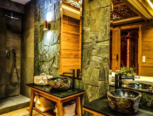 扎科帕内Gold Hotel的一间带两个水槽和石墙的浴室