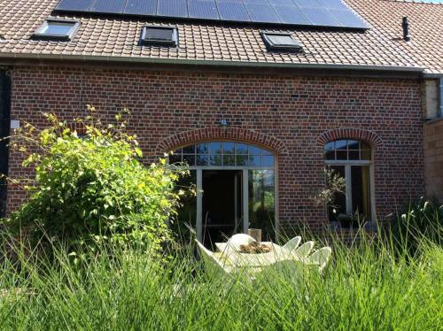 ZandvoordeKunstmin的屋顶上设有太阳能电池板的砖屋