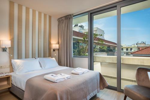 干尼亚特里亚农豪华公寓及套房酒店的酒店客房,配有带毛巾的床
