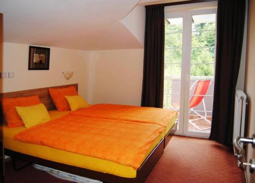 弗尔尼亚奇卡矿泉镇Vila Paradi的一间卧室配有一张带橙色毯子的床