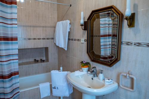 英雄港Quintal d'Angra的浴室配有盥洗盆、镜子和浴缸