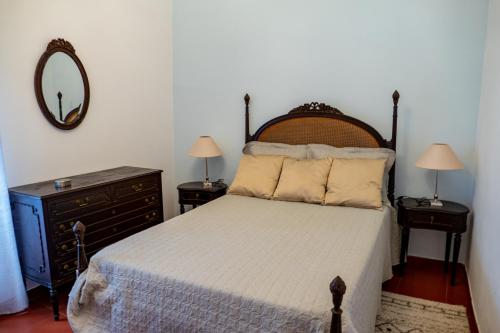 英雄港Quintal d'Angra的一间卧室配有床、镜子和梳妆台
